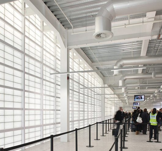 People in security line at Glasgow International Airport in Scotland, with Kalwall facade to provide security and privacy