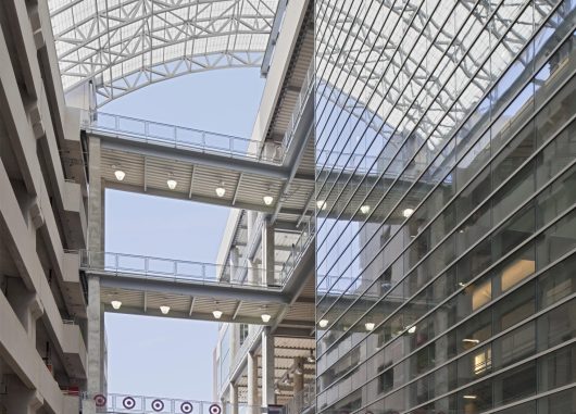 Multistory parking garage for shopping center featuring curved Kalwall skyroof® application over walkway connecting buildings